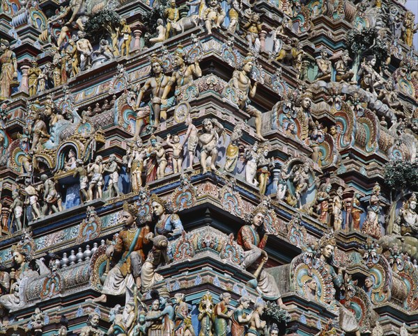 INDIA, Tamil Nadu, Madras, Kapaleeshwara Temple.  Detail of Dravidian style gopuram or pyramidal gateway showing multiple carved figures.