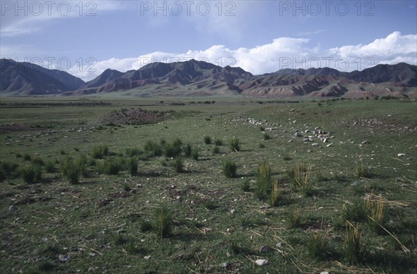 CHINA, Gansu, Grassland arealeading toward hills on the horizon