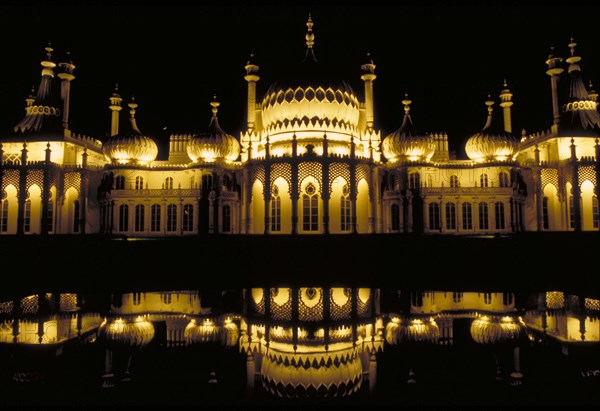 ENGLAND, East Sussex, Brighton, The Royal Pavilion illuminated at night and reflected in the lilly pond