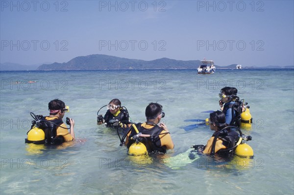 THAILAND, Phuket, Koh Hi, Also known as Coral Island. Tourists having scuba diving lessons in the clear waters with nearby boat