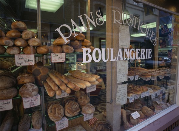 FRANCE, Nord-Picardy, Pas-de-Calais., "Boulogne.  Boulangerie in Haute Ville, part view of exterior with window filled with breads and cakes."
