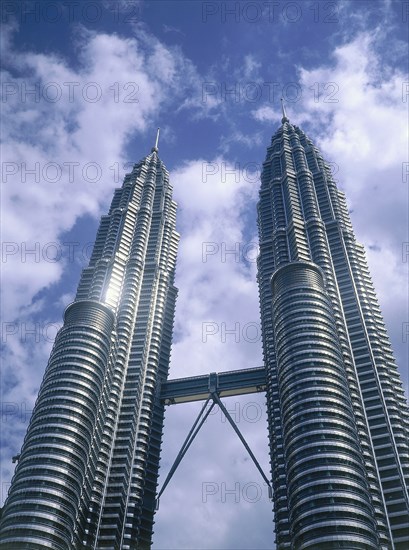 MALAYSIA, Mainland, Kuala Lumpur, Looking up towards The Petronas Towers with a lightly clouded sky behind