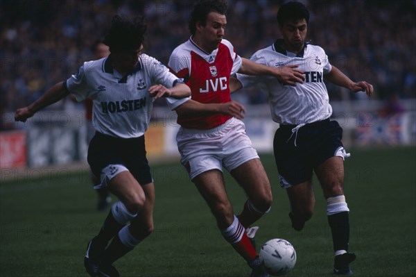 10051517 SPORT Ball Games Football Players tackle in Arsenal versus Spurs match.