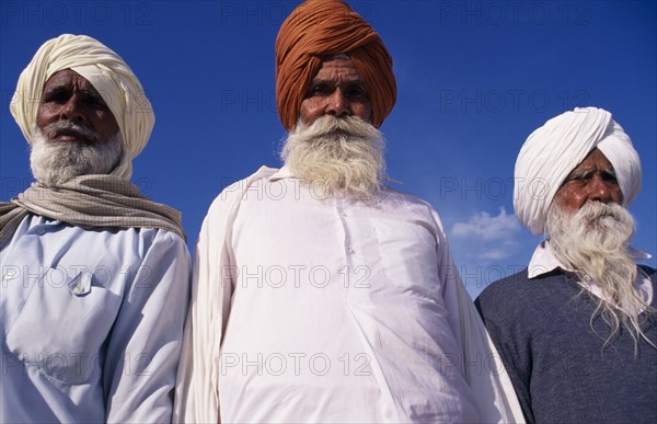 INDIA, Punjab , Amritsar, "Three elderly Sikh men, head and shoulders portrait from low angle looking up"
