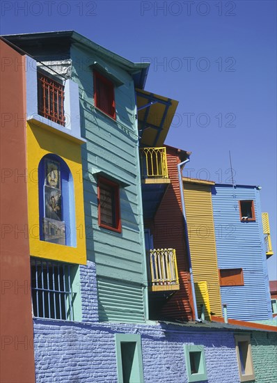 ARGENTINA, Buenos Aires, La Boca, Detail of brightly coloured wooden buildings set against a deep blue sky