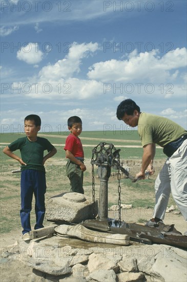MONGOLIA, Agriculture, Children and a man using well and pump