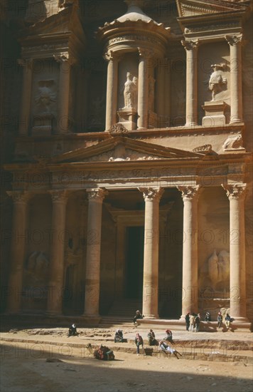 JORDAN, Petra, The Treasury with porticoed entrance carved into rock with camel and people in front