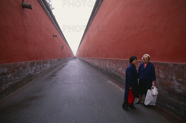 CHINA, Beijing , Imperial Palace, Two women standing between red walls