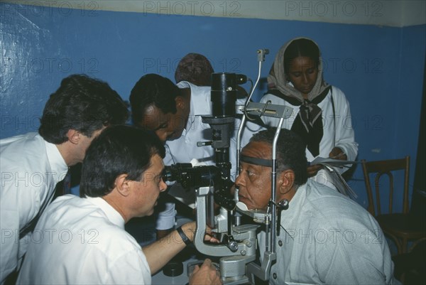 HEALTH, Eyes, Man leaning his head on a rest having an Orbis Eye Examination