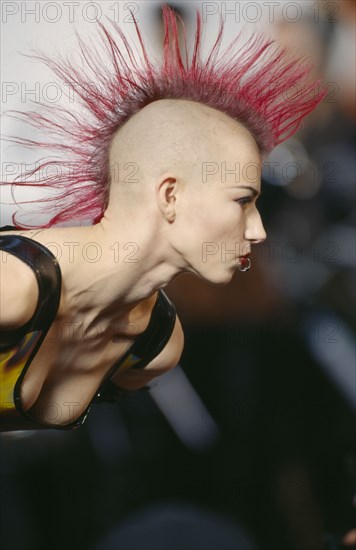 FASHION, Punk , Hairstyle / Piercing, Woman with Pink spiked hair running in narrow strip down her head and a ring through her bottom lip at Alternative Fashion Show.
