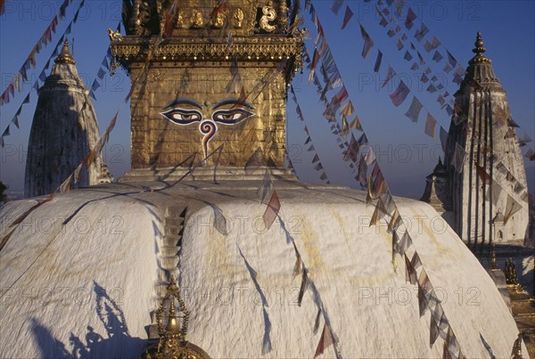 NEPAL, Kathamndu Valley, Swayambhunath, Swayambhunath Temple roof with painted eyes of Buddha and hung with prayer flags.