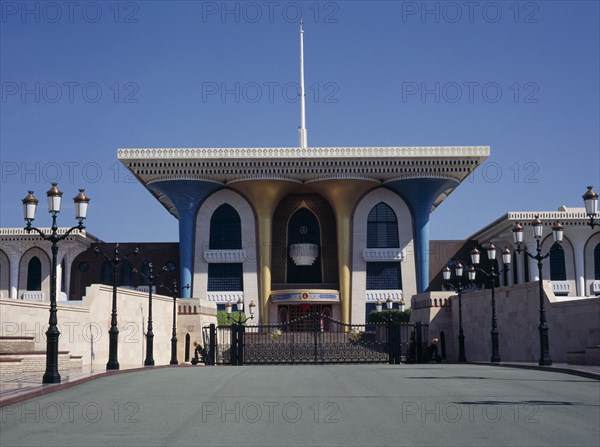 OMAN, Muscat , Sultans Palace, "Brightly colored architecture seen across lampost lined bridge,"