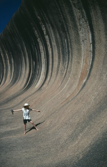 AUSTRALIA, Western Australia, Wave Rock, Tourist pretending to ride the waves like a surfer