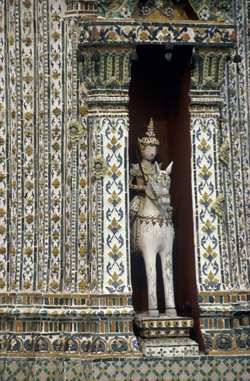 THAILAND, Bangkok, Wat Phra Kaeo close up statue of a horseman set into an alcove of a decorative building