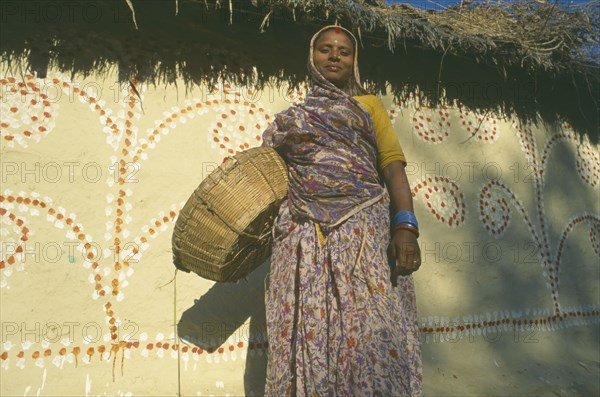 NEPAL, Madhya Pradesh, Janakpur , Mithila woman standing in front of painted house.