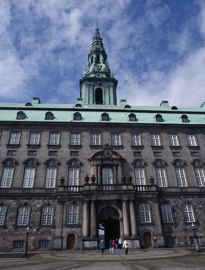 DENMARK, Copenhagen, Christiansborg Palace. Home of the Danish Parliament. Exterior view with green copper roof and visitors walking through.