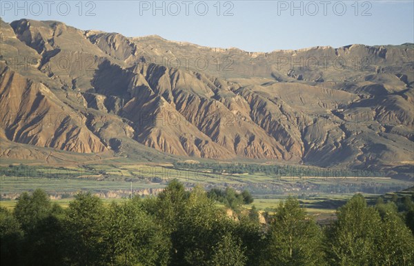 CHINA, Qinghai, General, Mountains behind trees and fields at the edge of the Tibetan plateau