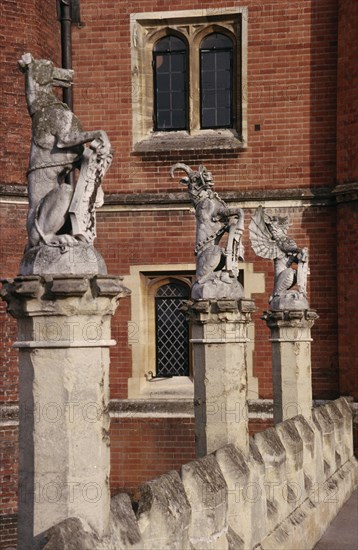 ENGLAND, London, Hampton Court Palace.  Detail of west facade with line of statues of heraldic beasts.