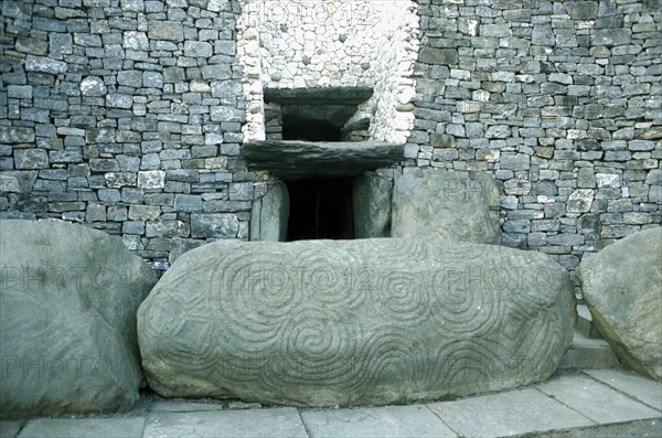 EIRE, County Meath, Newgrange, Entrance to Prehistoric Burial Site in the Boyne Valley with carved stone in the foreground