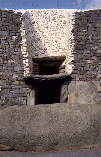 IRELAND, County Meath, Newgrange, Entrance to Prehistoric Burial Site in the Boyne Valley with carved stone in the foreground
