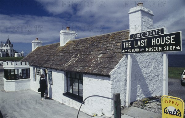 SCOTLAND, Highland , John O'Groats, Woman standing outside The Last House of the Most Northern point of Mainland Britain