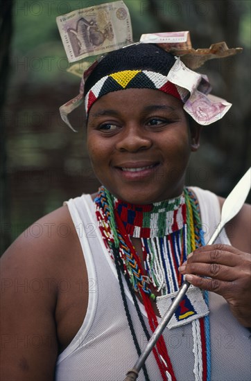 SOUTH AFRICA, KwaZulu Natal, Melmoth, Zulu woman holding a spear with money attached to head wear symbolic of her transition to womanhood