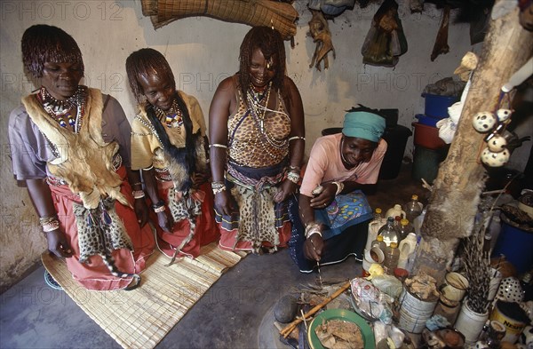 SOUTH AFRICA, KwaZulu Natal , Hlabisa, Zulu Sangomas or female diviners kneeling in their consulting room.