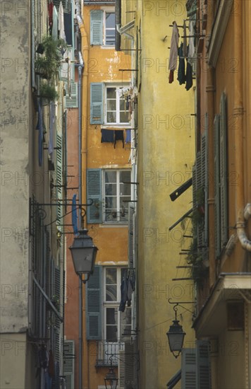 FRANCE, Prov Cote D’Azur  , Nice, Old Port Area narrow alley way with flat windows and washing hanging