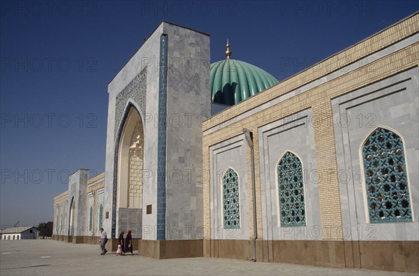 UZBEKISTAN, Near Samarkand, Al Bukhari Mausoleum. Exterior view along the facade with people at the entrance archway