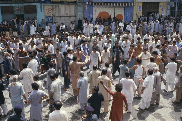 PAKISTAN, N W Frontier Province, Peshawar , "Mohurrum Festival.  Men beating their chests durring Shia muslim festival of mourning to commemorate the death of Husayn ibn Ali, grandson of Muhammad."
