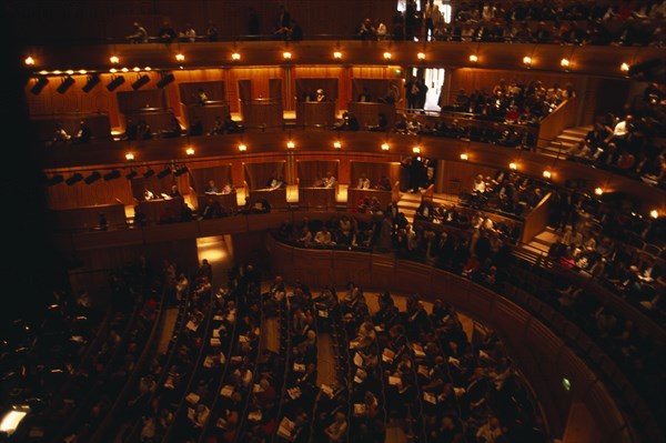 ENGLAND, East Sussex, Glyndebourne , Interior of auditorium with audience members taking their seats before Opera performance.