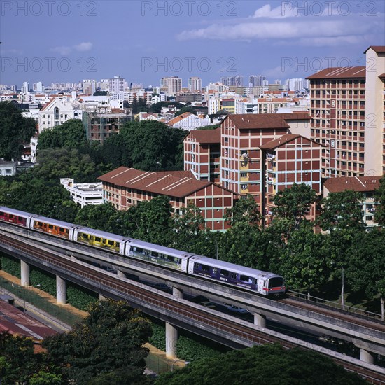 SINGAPORE, Near Kallang, MRT Mass Rapid Transport train with City Skyline and apartment blocks