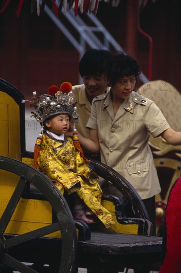 CHINA, Beijing, One child family.  Little boy dressed as emperor posing for photograph