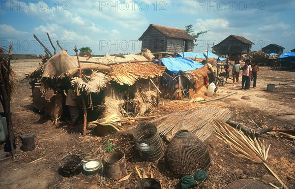 CAMBODIA, Kompong Thom, "Phnom, Prasat refugee camp.  Children standing outside makeshift huts."