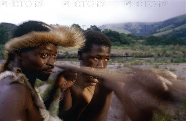 SOUTH AFRICA, KwaZulu Natal, Melmoth, Zulu man teaching young boy how to throw a spear.