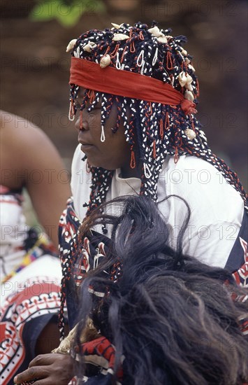 SOUTH AFRICA, KwaZulu Natal, Local woman in traditional headress holding fly whisk made from wildebeast tail