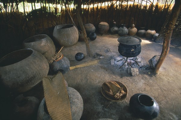 SOUTH AFRICA, KwaZulu-Natal , Melmoth, Simunye Lodge.  Interior of beer making hut with large vessels and pot on an open fire.