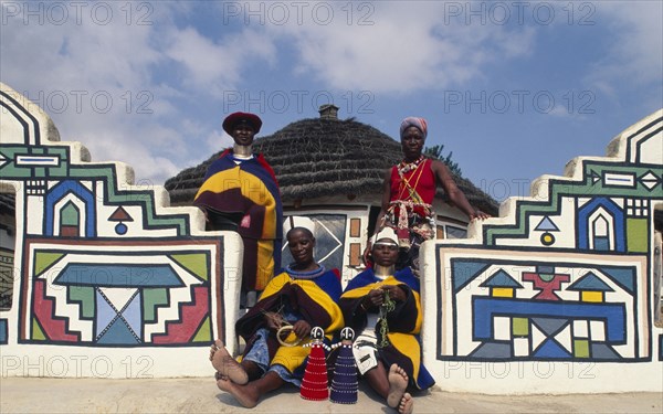 SOUTH AFRICA, KwaZulu Natal, Mpumalanga, Ndebele Cultural Village at White River with women in traditional dress outside the arts and crafts shop