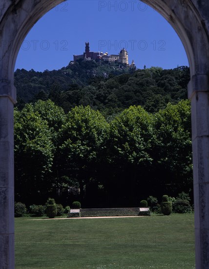 PORTUGAL, Estremadura, Sintra , Pena Palace seen in the distance through an arch in the gardens of Seteais Palace