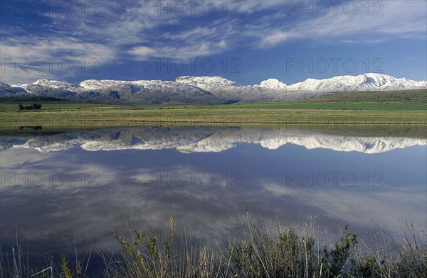 SOUTH AFRICA, Western Cape, Ceres, Landscape with snow covered mountains reflected in dam in the foreground.