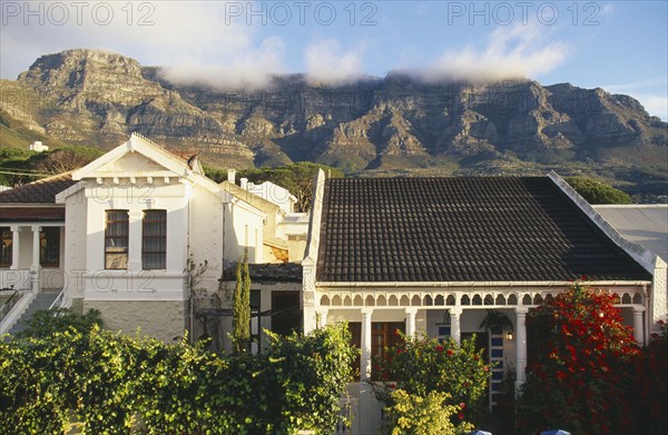 SOUTH AFRICA, Cape Province, Cape Town, Houses and gardens in the foreground and Table Mountain and 'Table Cloth' mist in background.