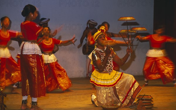 SRI LANKA, Kandy Dancers, Traditional dancers and man spinning plates on poles and fingers on stage.