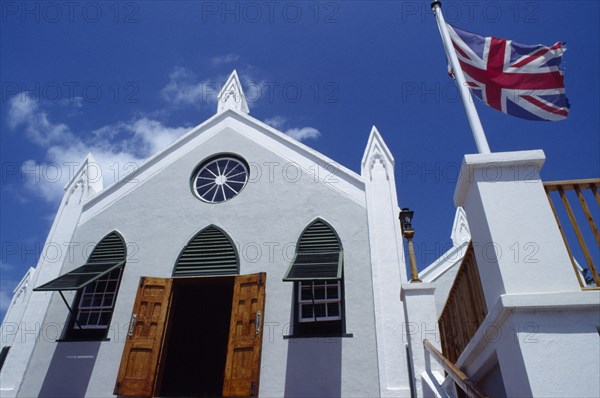 BERMUDA, St George’s Island, St. Georges, St Peters Church facade with open door and windows. British Union Jack flag flying outside.