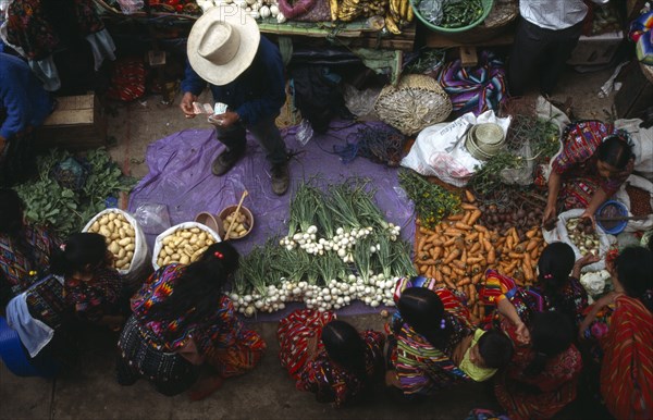 GUATEMALA, Chichicastenango , View looking down on market scene with people sitting at a vegetable stall