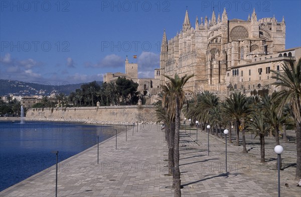 SPAIN, Balearic Islands, Majorca, Palma. View along the tree lined promenade toward La Seo Cathedral  with Almudaina Palace visible in the background