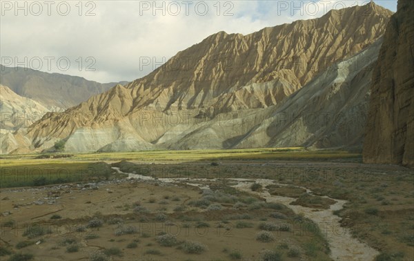 CHINA, Qinghai  , Yellow River , Eroded rocks above wheat fieldin  high altitude remote valley