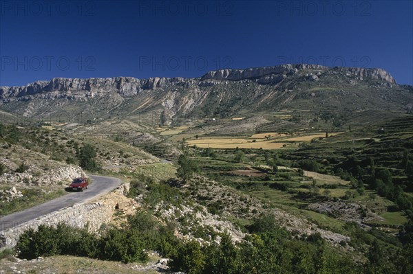 SPAIN, Pyrenees, Catalonia, Cerdana Valley in the foothills of the Pyrenees with car parked on road in foreground.