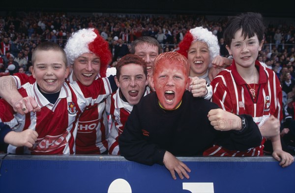 10085687 SPORT  Ball Games Football A group of young football supporters in red and white kit