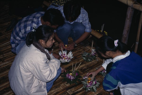 THAILAND, Chiang-Mai  Festival, "'Yipeng' Loi Krathong Festival, Lighting candles on Krathong to be floated on river for luck "