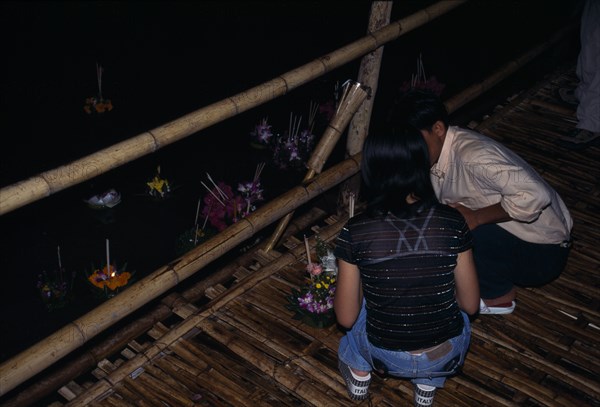 THAILAND, North, Chiang-Mai , "'Yipeng' Loi Krathong Festival, Lighting candles on Krathong to be floated on river for luck "
